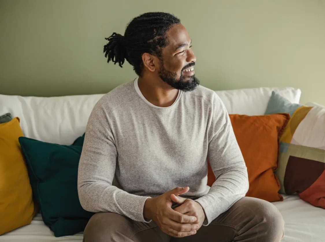 smiling man sitting on sofa